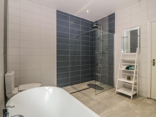 a bathroom with a tub and a shower and a toilet at Gwylan Uchaf in Y Felinheli