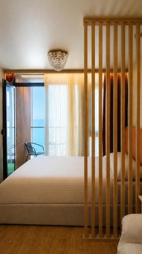 a bedroom with a large bed with a view of the ocean at Nautilus Apartment in Batumi