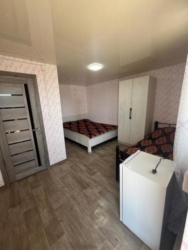 an empty room with two beds and a door at Prestizh Guest House in Tamchy
