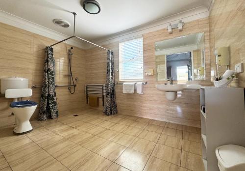 a bathroom with a sink toilet and a mirror at Gunnedah Lodge Motel in Gunnedah