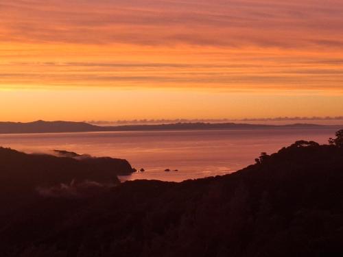 a view of the ocean at sunset at Totaranui Accommodation Chalet 2 in Tata Islands