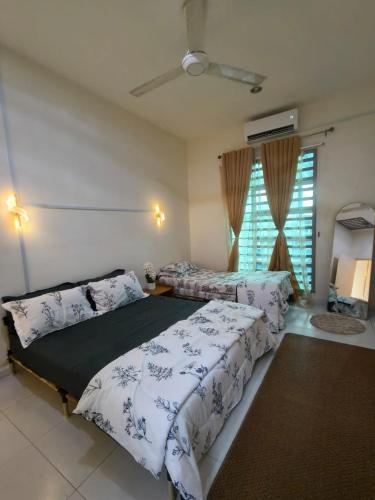 a bedroom with two beds and a window at Homestay D' Aura Pool Melaka in Ayer Keroh