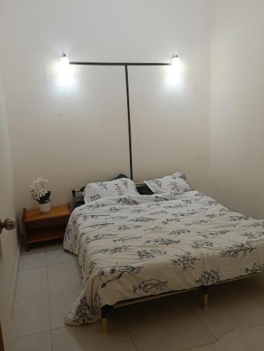 a bedroom with a bed with a lamp on it at Homestay D' Aura Pool Melaka in Ayer Keroh