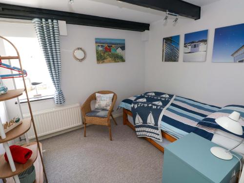 a small bedroom with a bed and a chair at The Stables in Flemingston
