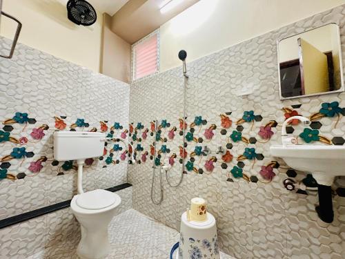 a bathroom with a toilet and a sink at Aravind Guest House in Chidambaram
