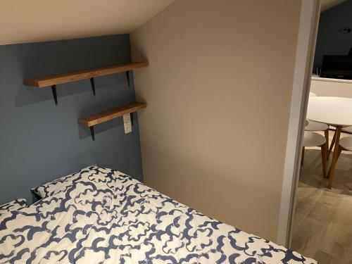 a bedroom with a bed and shelves on the wall at The Tiny House in Nieuwpoort