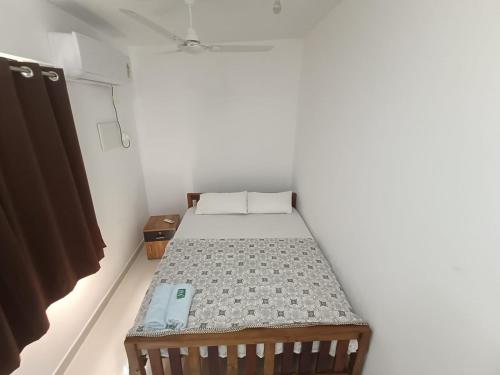 a small bedroom with a bed in a room at Harmony Residence in Trivandrum