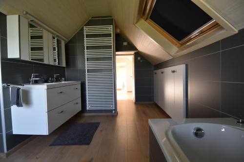 a bathroom with a sink and a bath tub at Aan de Vleterbeke in Oostvleteren