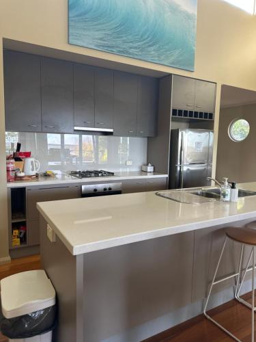 a kitchen with gray cabinets and a counter top at Unit 4 The village light house in Metung