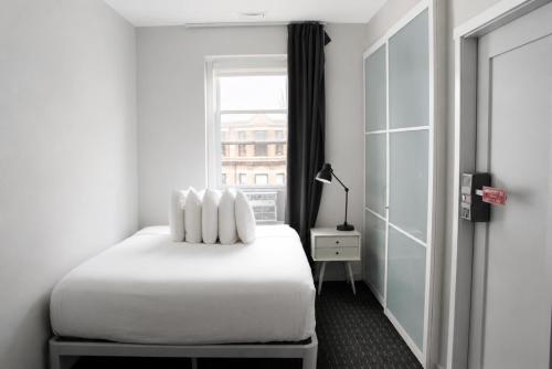 a bedroom with a white bed and a window at Comfortable Studio in Back Bay, Newbury St. #7 in Boston