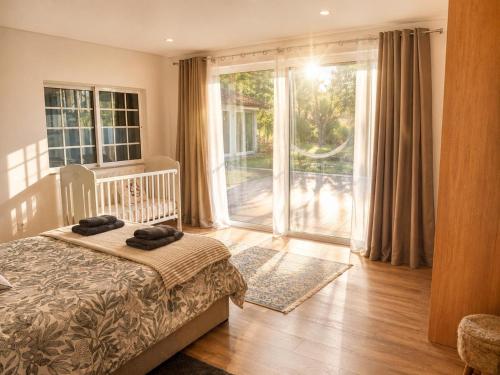a bedroom with a bed and a large sliding glass door at Préfacio Do Silêncio in Godinhaços