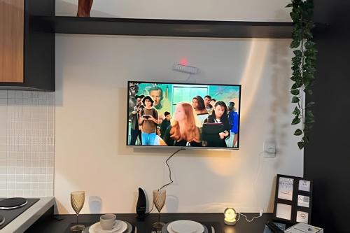 a tv hanging on a wall in a kitchen at Studio Luar 611: Executivo Premium - SmartPituba in Salvador