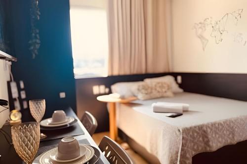 a small room with a bed and a table with dishes at Studio Luar 611: Executivo Premium - SmartPituba in Salvador