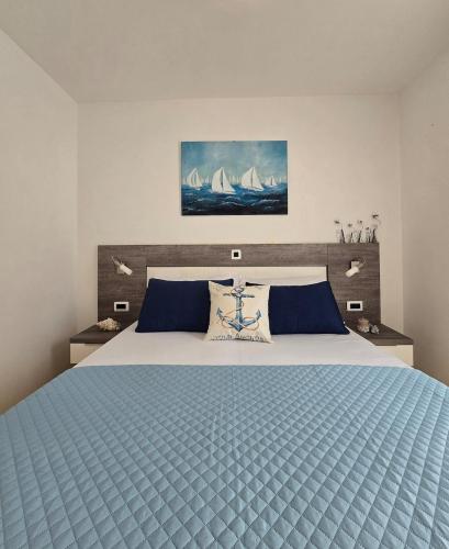 a bedroom with a large bed with a blue comforter at Apartman Oscar with pool access in Petrcane