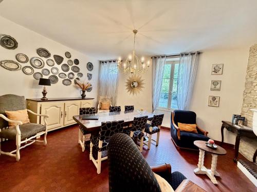 a living room with a dining room table and chairs at Le Clos des Lys, Maison de Pays Raffinée Proche de la Mer in Saint-Georges-dʼOléron