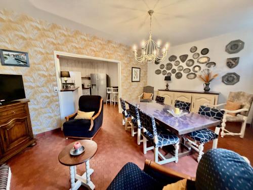 a kitchen and living room with a dining table and chairs at Le Clos des Lys, Maison de Pays Raffinée Proche de la Mer in Saint-Georges-dʼOléron