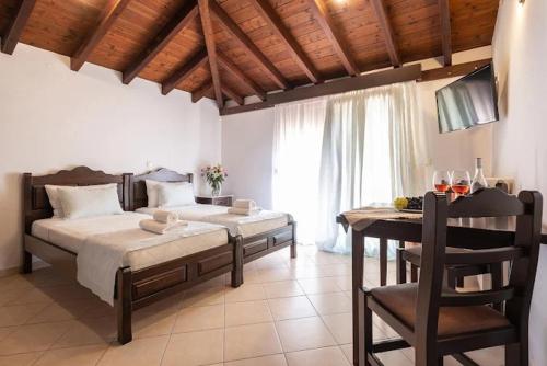 a bedroom with a bed and a table with a dining room at Afrodite Hotel Apartments in Myrina