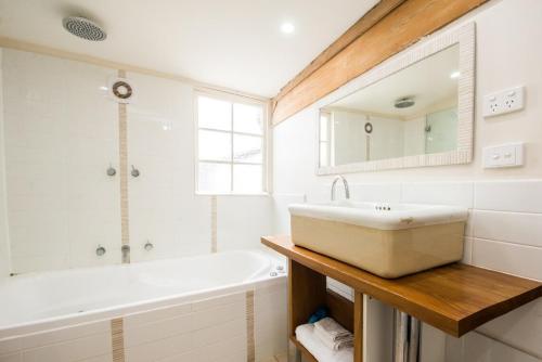 a bathroom with a white tub and a sink at Mrs Banks in Robe