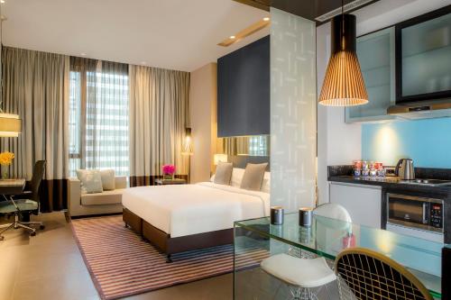 a hotel room with a bed and a living room at The Boulevard Arjaan by Rotana in Amman
