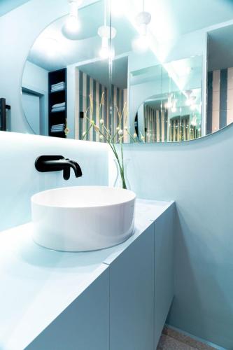 a white bathroom with a sink and a mirror at Ferienapartment OVIX in Okrug Donji