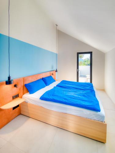 a bedroom with a large bed with blue sheets at Ferienapartment OVIX in Okrug Donji