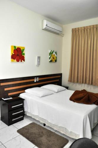 a hotel room with two beds and a window at Imperial Hotel in Juiz de Fora