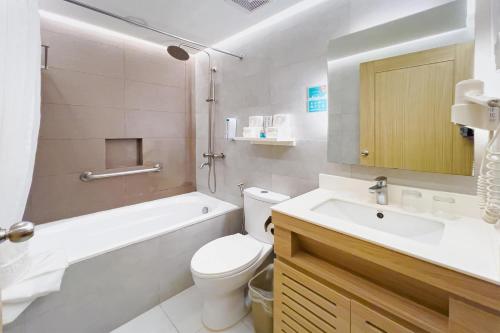 ein Badezimmer mit weißer Toilette und Waschbecken in der Unterkunft Microtel by Wyndham Tarlac in Tarlac City