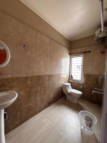 a bathroom with a toilet and a sink at Niyor Nest in Guwahati