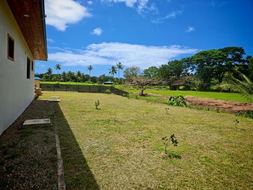 a yard with a fence and a field of grass at villa 911 in Pacific Harbour
