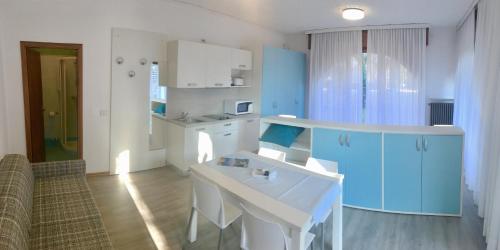 a kitchen with blue and white cabinets and a table at Casa Vittoria in Nago-Torbole