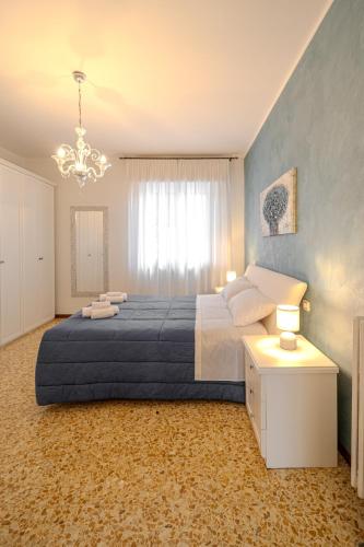 a bedroom with a large bed and a chandelier at Casa Lella in Novara