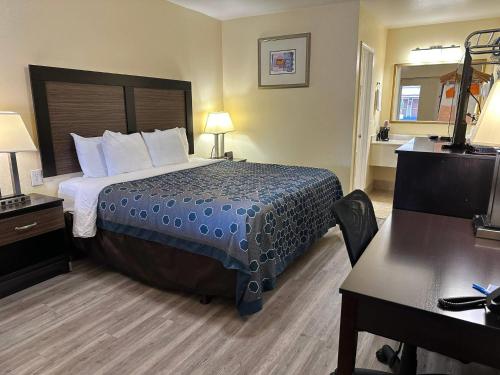 a hotel room with a bed and a desk at Rodeway Inn Medford South I-5 in Medford