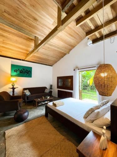 a bedroom with a large bed and a living room at Baker's cottage in Kosgoda