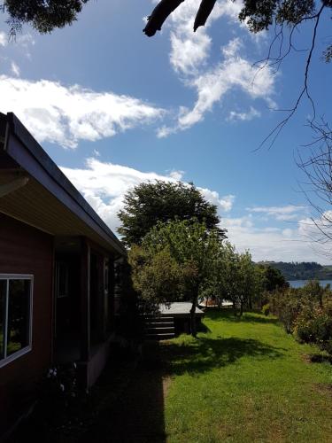 a house with a grassy yard next to a building at Casa Bordemar in Castro