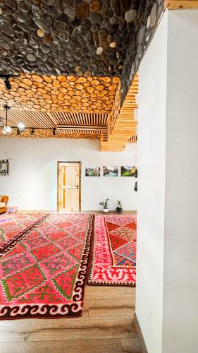 a room with a red rug on the floor at Kezgin Guest House in Naryn