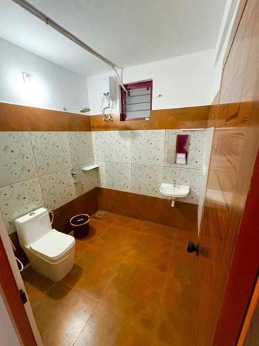a bathroom with a toilet and a sink at Hotel Paradise Kovalam in Trivandrum