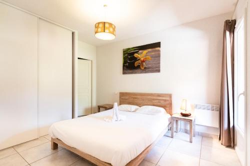 a bedroom with a white bed in a room at Le Domaine du Thronnet in Figanières