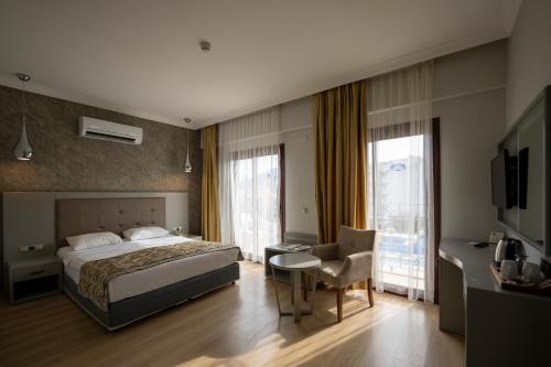 a bedroom with a bed and a desk and a chair at Pasa Garden Beach in Marmaris