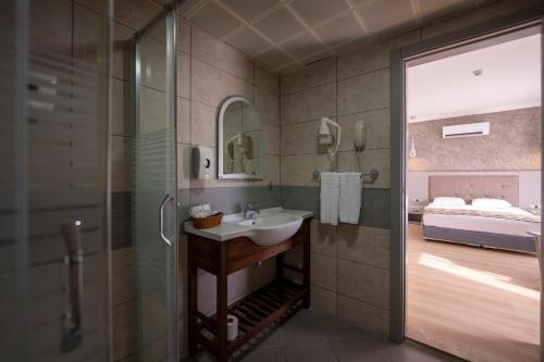 a bathroom with a sink and a shower and a bed at Pasa Garden Beach in Marmaris