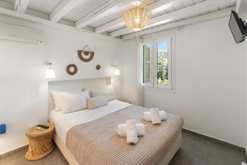 a bedroom with a bed with two towels on it at LausAndros Suites in Andros