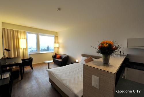 a hotel room with a bed and a desk and a room at Guggach Apartôtel in Zürich