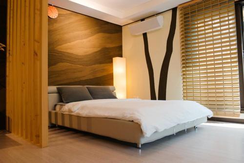 a bedroom with a bed with a tree on the wall at Byeoldeul-ui Gichim Pension in Inje