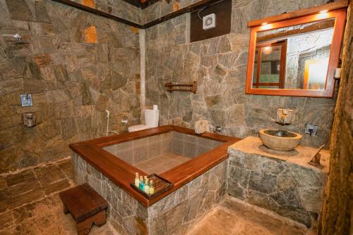 ein großes Steinbadezimmer mit Badewanne und Waschbecken in der Unterkunft Tea Cottage Resort - Nawalapitiya in Kandy