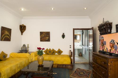 a living room with a yellow couch and a table at Villa Quieta in Essaouira