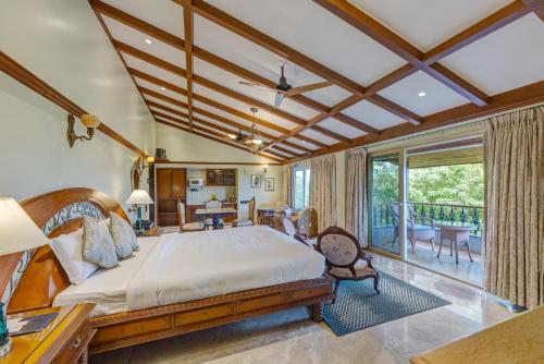 a bedroom with a large bed and a balcony at Ramsukh Resorts and Spa in Mahabaleshwar
