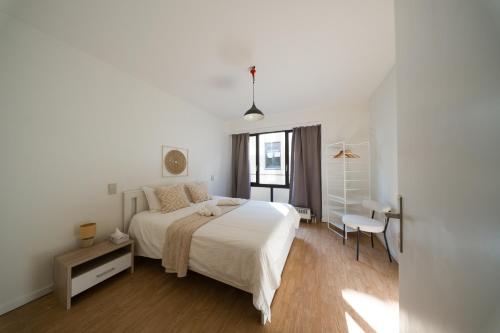 a white bedroom with a large bed and a desk at Spacious Apartment at Top Location Grote Markt in Sint-Niklaas