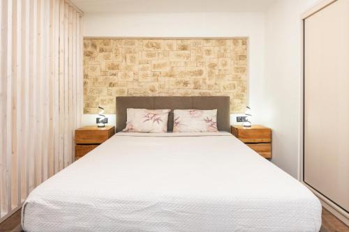a bedroom with a large white bed with two night stands at Corfu nest apartment in Ágios Rókkos