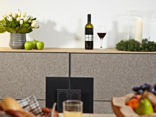 a counter with a bottle of wine and a plate of fruit at Schittlerhaus in Oberstdorf