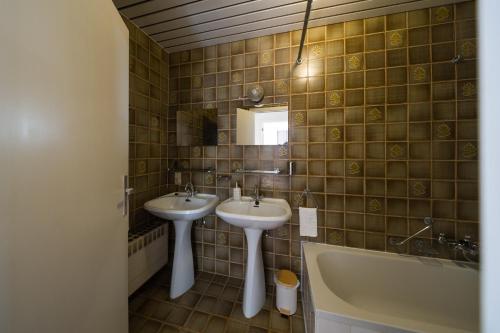 a bathroom with two sinks and a bath tub at Spacious Apartment at Top Location Grote Markt in Sint-Niklaas