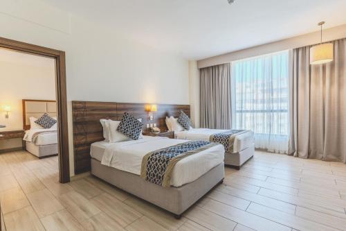 a hotel room with two beds and a mirror at Lacosta Hotel in Aqaba